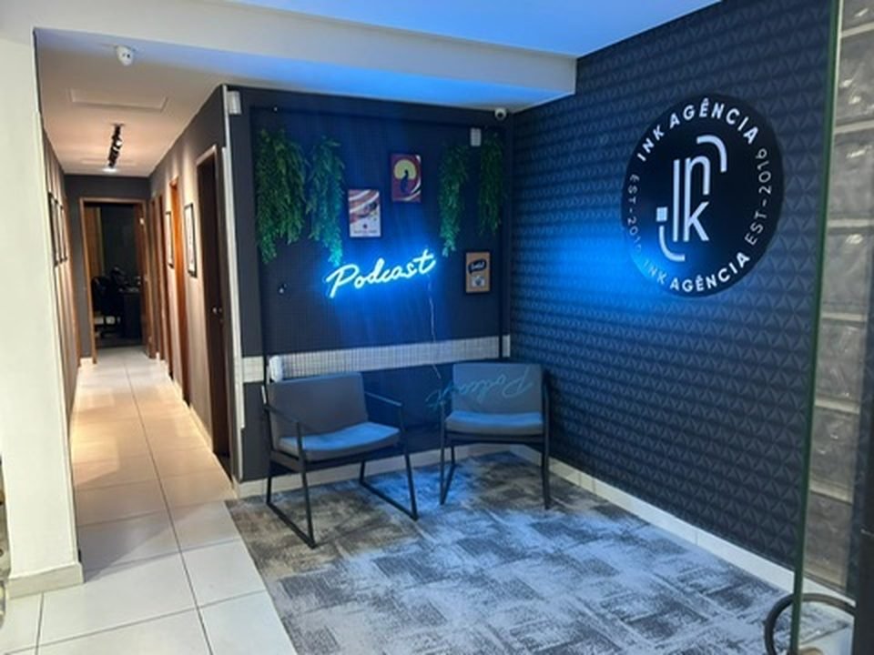 Recepção do INK Studio com painel de neon Podcast