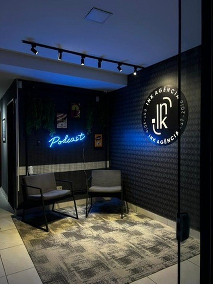 Recepção da INK Agência em Vila Velha com painel de neon